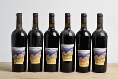 six bouteilles de vin sont alignées sur une table en bois