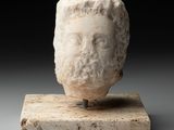une tête d'homme antique posée sur un socle en marbre