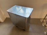 une petite table en métal à deux tiroirs, montée sur roulettes, dans une pièce