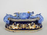 a blue and gold vase with two fish on it