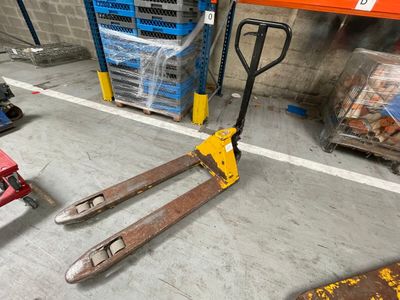 une fourche sur une palette dans un entrepôt, à côté d'autres palettes