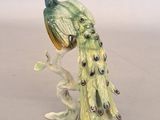 a figurine of a peacock sitting on a branch