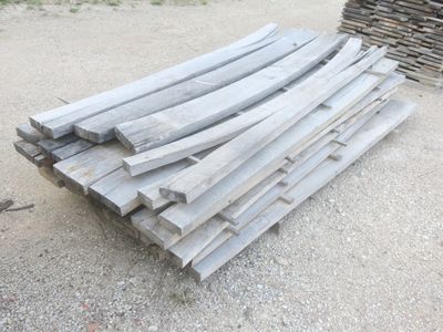 un tas de bois posé par terre à côté d'un tas de bûches