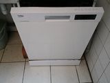 a dishwasher in the corner of a kitchen with a plate of food on top of it