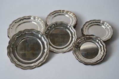 six assiettes plaquées argent, avec des bords argentés sur un fond blanc
