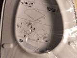 a white toilet with a plastic cover on the floor