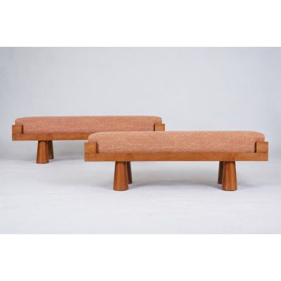a pair of wooden benches with orange upholstered cushions