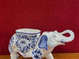 a blue and white elephant figurine sitting on a wooden table