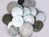 un tas d'argent et de pièces d'argent posé sur une surface blanche