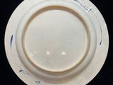 a white plate with blue designs on it on a black surface