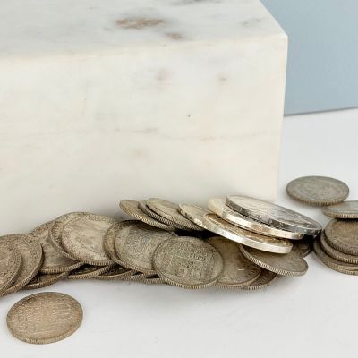 un bloc de marbre blanc sur lequel est posée une pile de pièces de monnaie