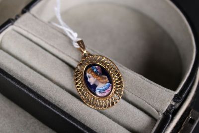 un collier orné d'une image représentant une femme, présenté dans un écrin