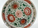 une photo d'une assiette décorée de fleurs, posée sur un présentoir