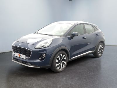 Une voiture bleue est garée dans une pièce au sol noir.