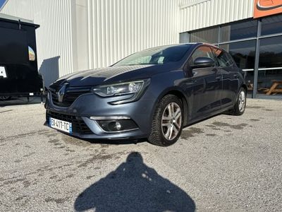 La voiture grise est garée devant un immeuble, sur un parking.