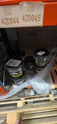 un pot de peinture posé sur une palette dans un magasin