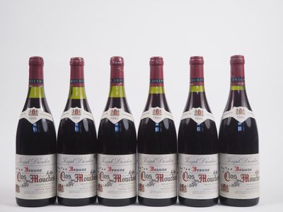 six bottles of wine lined up in a row on a white surface
