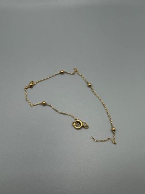 un bracelet en chaîne d'or orné d'un petit pendentif en forme d'œil maléfique