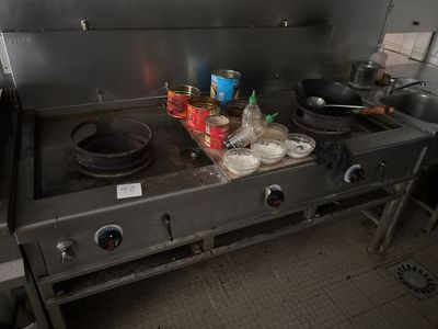 une cuisinière sur laquelle sont posées des casseroles et des poêles, dans une cuisine
