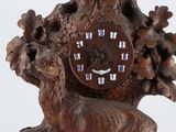 a wooden clock that has a deer on it ' s side