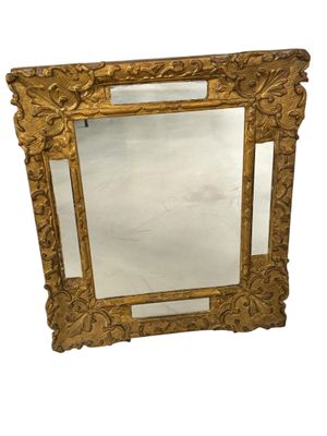 une image d'un miroir encadré d'or sur un fond blanc