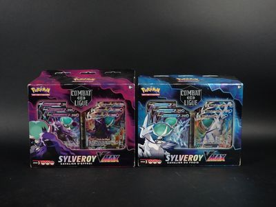 deux boîtes de cartes à collectionner Pokémon posées sur une surface noire