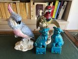 trois figurines posées sur une table, avec une bibliothèque en arrière-plan