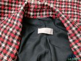 a close up of a red and black jacket with a white label on it