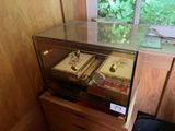 a glass display case with two books on top of it
