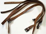 une paire de lanières en cuir marron sur un fond blanc