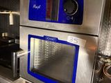 silver and blue ovens in a commercial kitchen with tile flooring