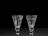two empty wine glasses on a black table with a black background