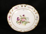 a plate with flowers painted on it on a black background