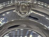 a silver plate with a crest on the top of it