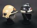 two fire fighters helmets with helmets on display against a black background