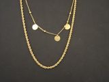 un gros plan d'un collier orné de pièces de monnaie sur fond noir