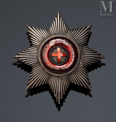 a close up of a metal star with a red and black design on it