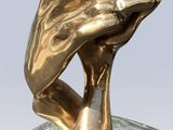 statue of two hands holding each other on a marble base