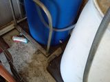 a blue barrel and a white bucket on the floor