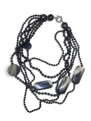 a close up of a necklace with black beads and black beads