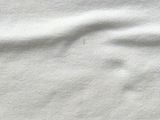 a close up of a white shirt with a black cat on it