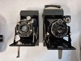 two old cameras sitting on a table next to each other