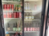Des bouteilles de soda et de boissons gazeuses sont exposées dans une armoire réfrigérée