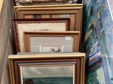de nombreuses œuvres d'art encadrées posées sur une étagère dans une pièce