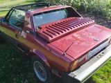 a red car that is parked in the grass