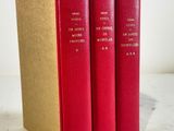 three red books sitting on top of each other on a table