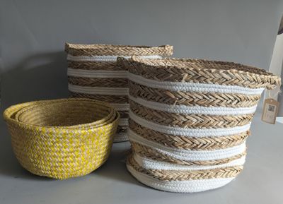 three woven baskets sitting on top of a table next to a yellow bowl