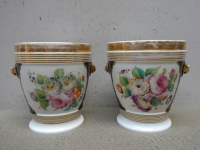 deux vases avec des fleurs peintes dessus, posés sur une table