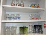 de nombreux verres et bocaux sur les étagères de la cuisine