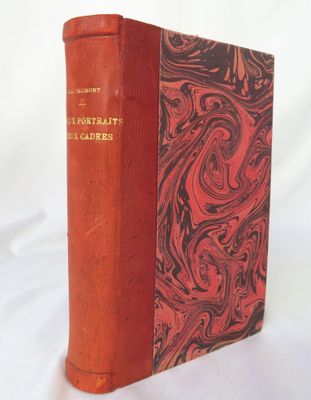 un vieux livre à la couverture rouge posé sur une table blanche